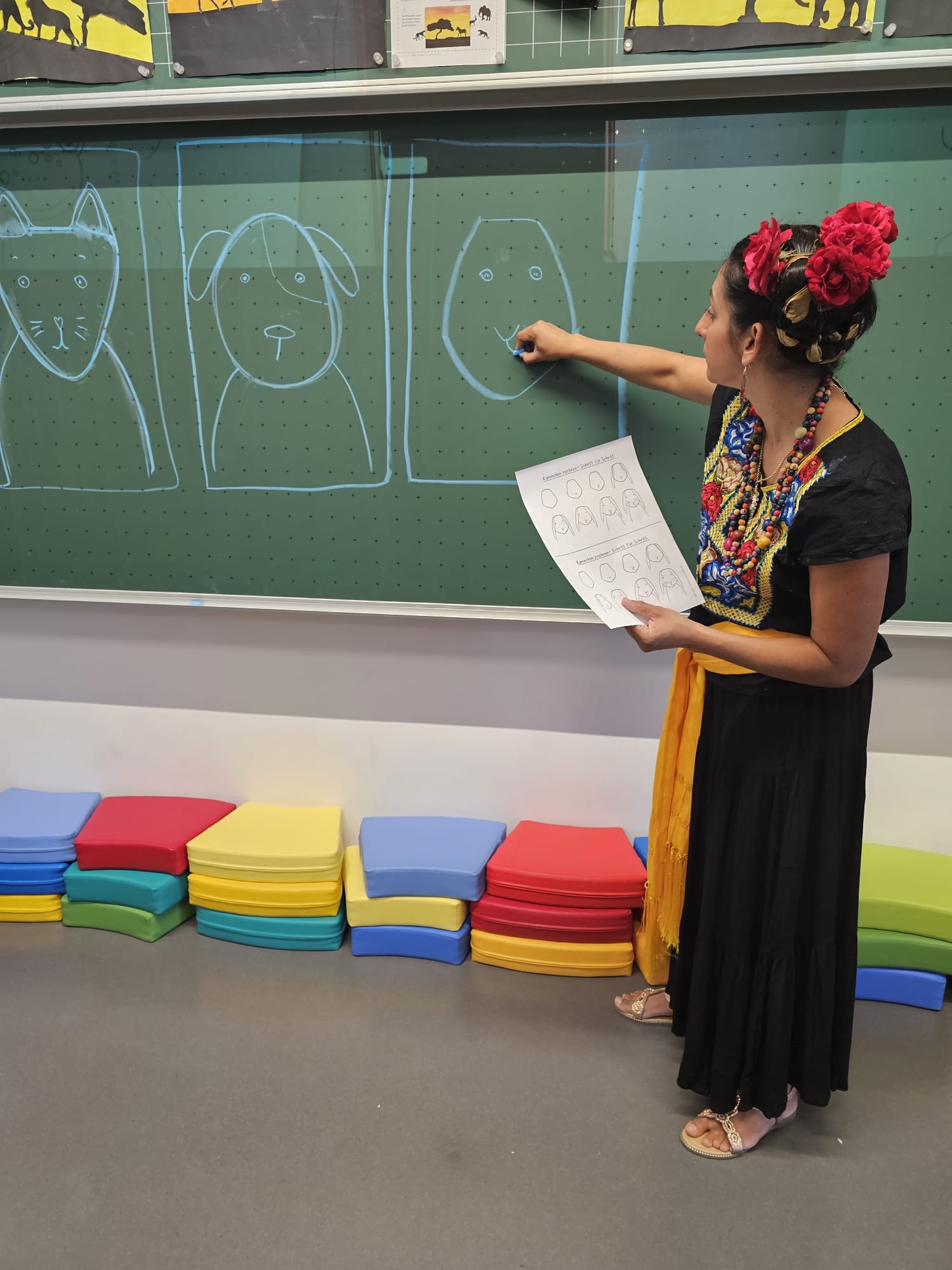 Lizeth erkl&auml;rt die Maltechnik an der Tafel